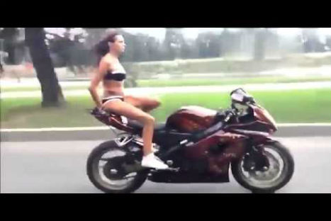 Joven hace piruetas en una motocicleta en ropa de baño-VIDEO
