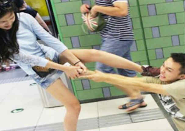 Arrastra a su novio por el metro por no dejar su celular (FOTOS)
